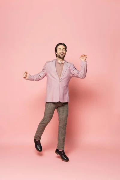 Positive host of event in jacket walking on pink background — Stock Photo