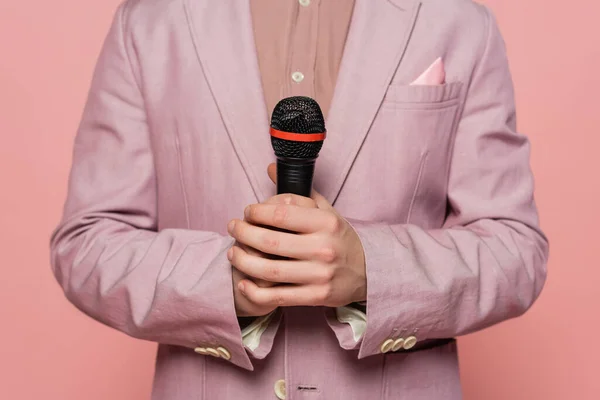 Cropped view of host of event in jacket holding microphone isolated on pink — Stock Photo