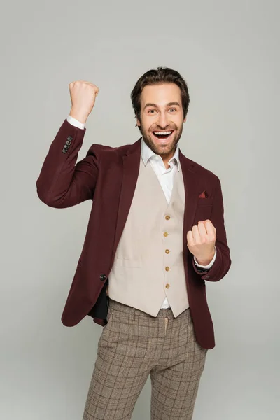 Showman animado em blazer vermelho gesticulando enquanto se alegra isolado no cinza — Fotografia de Stock