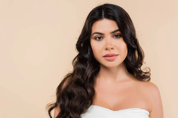 Portrait of woman with wavy hairstyle looking at camera isolated on beige — Photo de stock