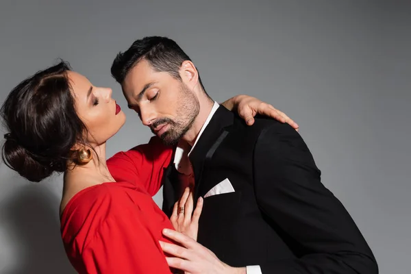 Elegant man touching sensual girlfriend in dress on grey background — Photo de stock