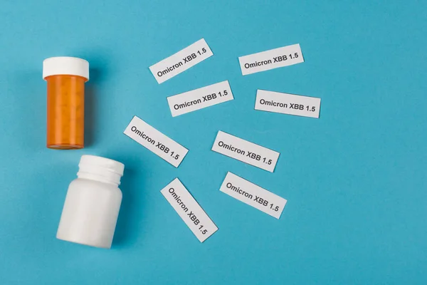 Top view of pills and omicron xbb lettering on blue background - foto de stock