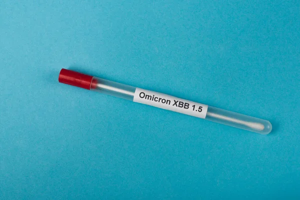 Top view of omicron xbb lettering on cotton swab on blue background - foto de stock