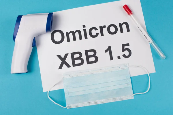 Top view of omicron xbb lettering near throat swab and pyrometer on blue background — Stock Photo