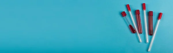 Top view of blood samples near throat swabs on blue background, banner — Stock Photo
