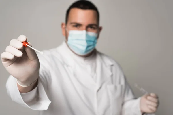 Blurred scientist in latex gloves holding throat swab isolated on grey - foto de stock