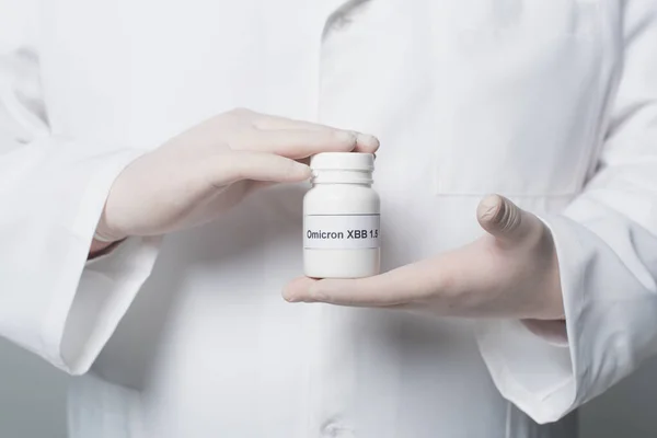 Обрезанный вид врача в белом халате и перчатках, держащих банку с omicron xbb буквы изолированы на сером — стоковое фото