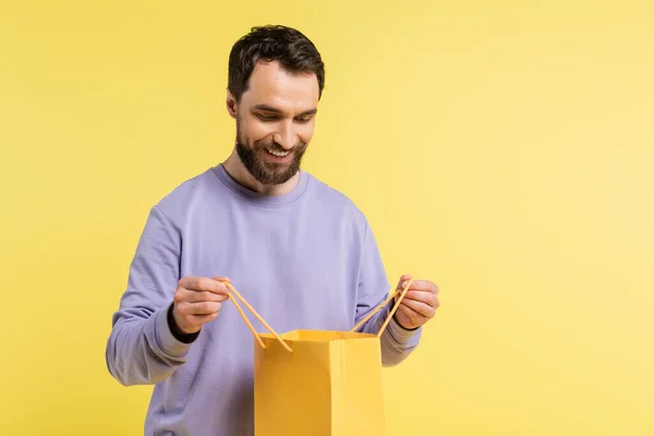 Ein bärtiger Mann blickt vereinzelt in eine gelbe Einkaufstasche — Stockfoto