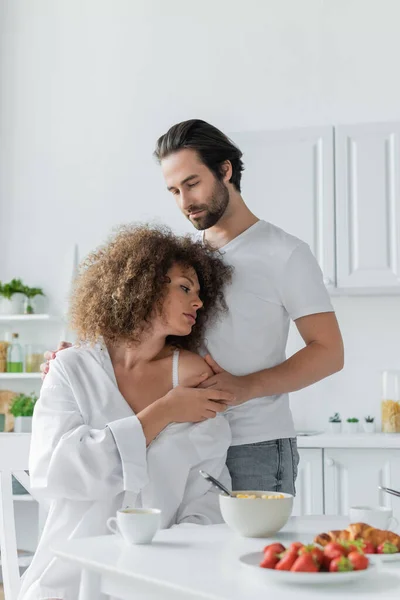 Bearded man undressing sensual girlfriend in white shirt during breakfast — Foto stock
