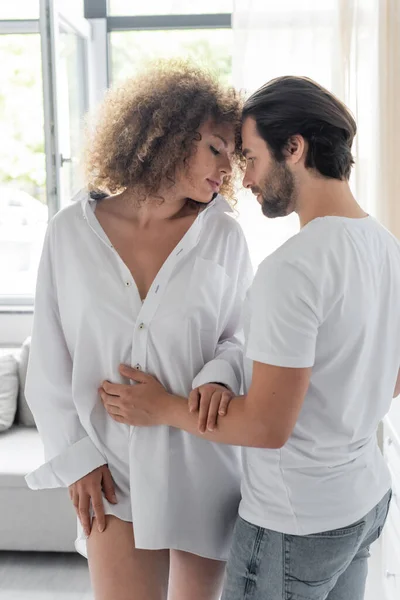 Bearded man in jeans seducing sensual girlfriend in white shirt — Photo de stock