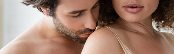 Bearded and shirtless man kissing shoulder of sexy woman, banner — Stock Photo