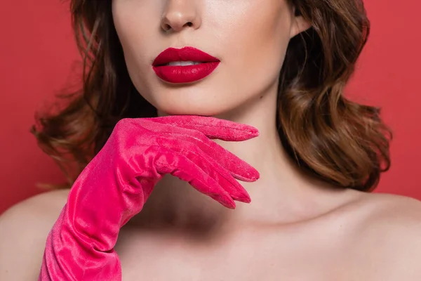 Cropped view of young woman with magenta color glove isolated on pink — стоковое фото