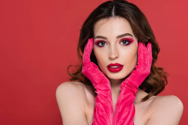 Portrait of young woman with magenta color gloves looking at camera isolated on pink — Fotografia de Stock
