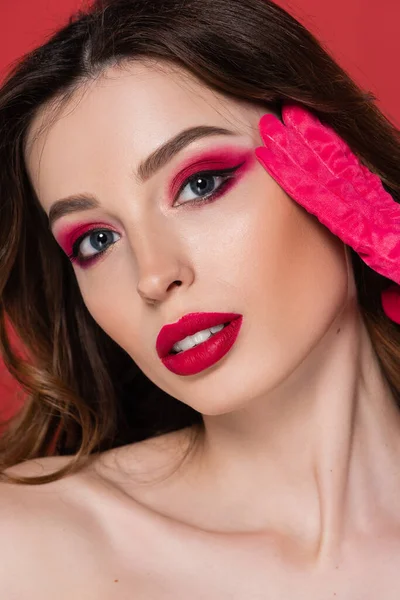 Portrait of young woman with magenta color eye makeup looking at camera isolated on pink — Stockfoto