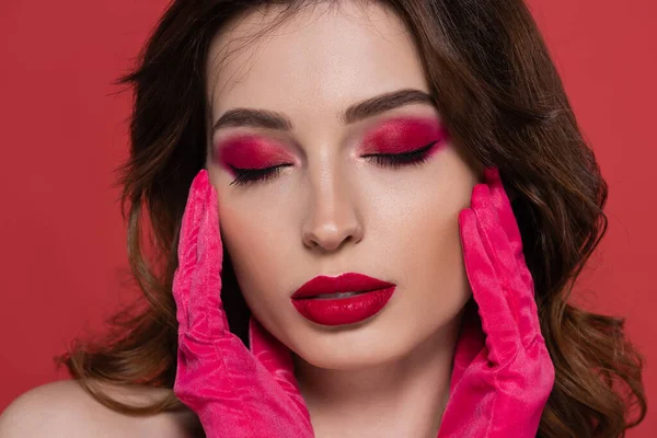 Portrait of brunette woman with magenta color makeup and closed eyes isolated on pink — Fotografia de Stock