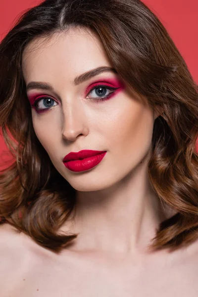 Portrait of young woman with magenta color makeup and bright lipstick looking at camera isolated on pink — Stock Photo