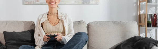 KYIV, UKRAINE - OCTOBER 24, 2022: cropped view of cheerful young woman holding joystick while playing video game — Foto stock