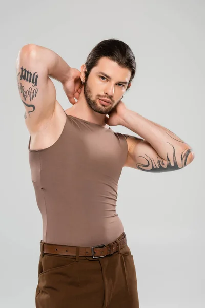 Muscular tattooed man in tank top posing isolated on grey — Stock Photo