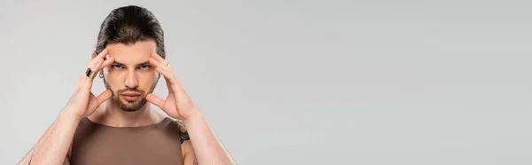 Brunette and tattooed man touching face isolated on grey, banner — Stock Photo