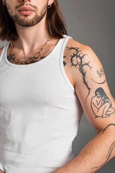 Cropped view of young tattooed man in sleeveless shirt isolated on grey - foto de stock