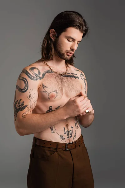 Shirtless and tattooed man standing isolated on grey — Stock Photo