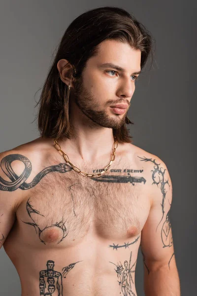 Portrait of shirtless tattooed man looking away isolated on grey — Photo de stock