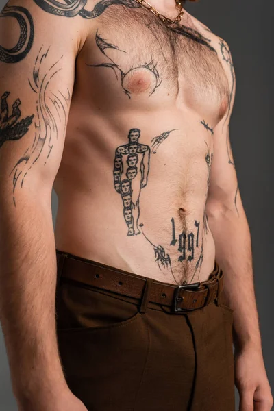 Обрізаний вид татуйованого і без сорочки чоловіка ізольовано на сірому — стокове фото
