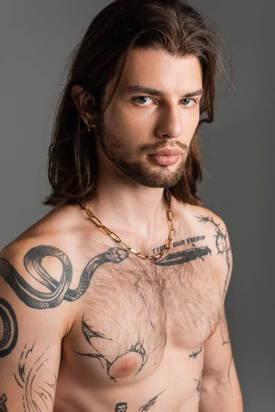Portrait of shirtless and tattooed model looking at camera isolated on grey — Photo de stock
