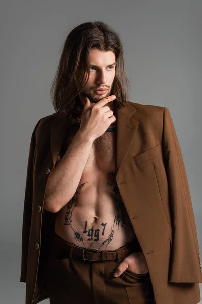 Fashionable tattooed man in jacket posing isolated on grey - foto de stock