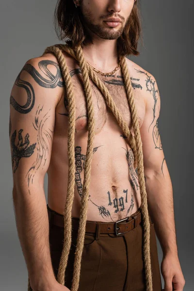 Cropped view of bearded and tattooed man with rope isolated on grey — Foto stock