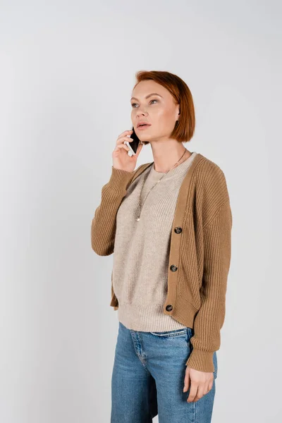Redhead woman in casual clothes talking on smartphone isolated on grey — Foto stock