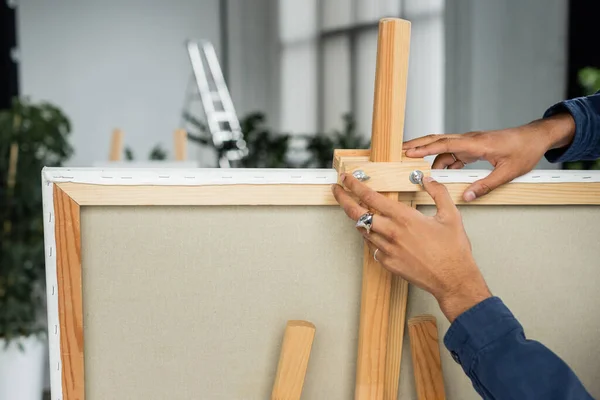 Cropped view of african american artist putting canvas on easel — Stock Photo