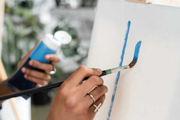 Cropped view of african american artist painting on canvas in workshop — Stock Photo