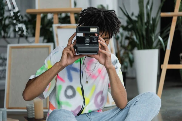 African american artist taking photo on vintage camera in studio — Photo de stock