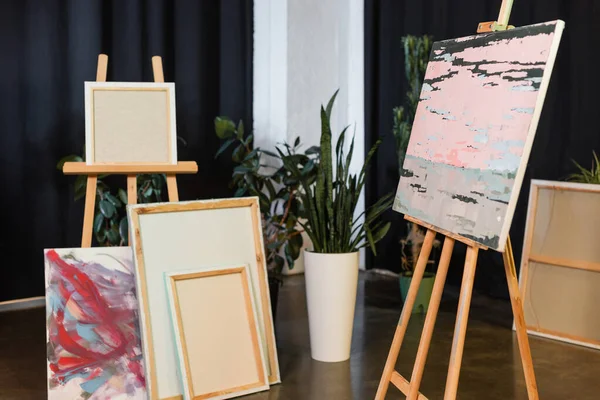 Peintures et chevalets sur le sol dans un atelier d'art — Photo de stock