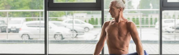 Без сорочки і сіро-волохатий чоловік дивиться в студії йоги, банер — стокове фото