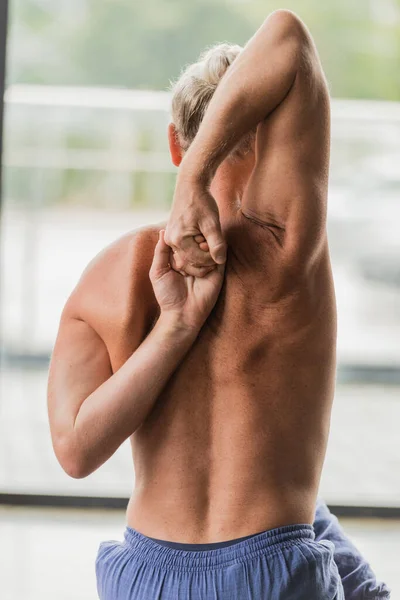 Rückansicht eines grauhaarigen Mannes, der die Hände hinter dem Rücken ballt — Stockfoto