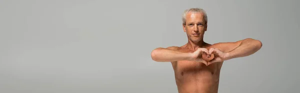 Shirtless man showing heart sign isolated on grey, banner — Stock Photo