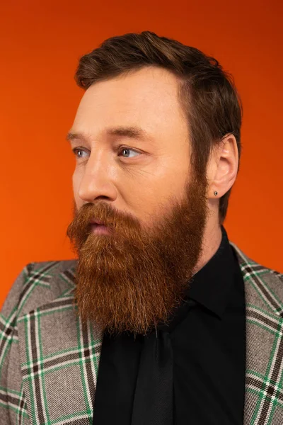 Portrait of stylish bearded man looking away isolated on red — Stock Photo
