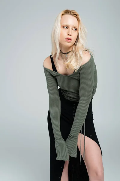 Blonde woman in long sleeve shirt and sexy skirt looking away isolated on grey — Stockfoto