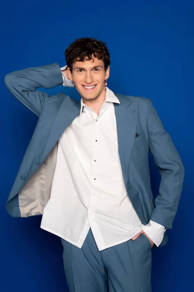 Positive model in suit and shirt posing on blue background — Photo de stock