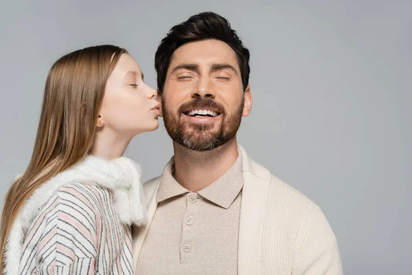 Portrait of cheerful kid kissing cheek of father with smiling closed eyes isolated on grey — Stock Photo