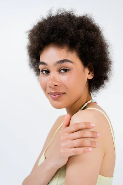 Portrait of young african american woman touching shoulder isolated on grey — Stock Photo