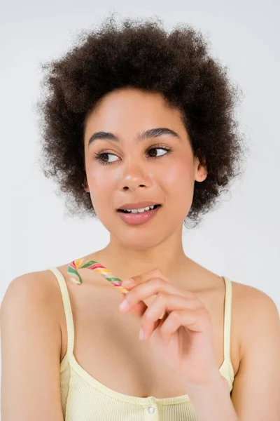 Портрет африканской американки, держащей в руках конфетку, изолированную на сером — стоковое фото