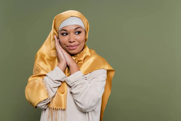 Giovane donna multirazziale in hijab guardando lontano isolato sul verde — Foto stock