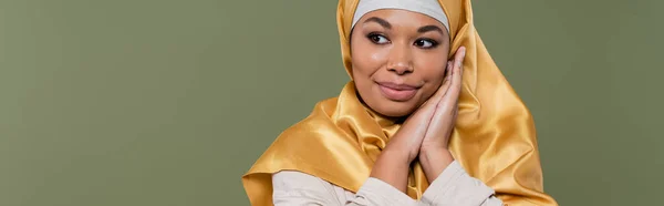 Красивая многорасовая женщина в хиджабе смотрит в сторону изолированных на зеленый, баннер — стоковое фото