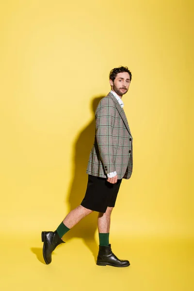 Volle Länge des trendigen Modells in Shorts und Jacke auf gelbem Hintergrund — Stockfoto
