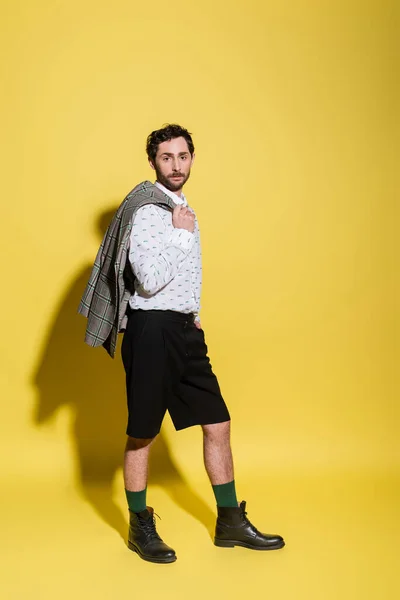 Volle Länge des stylischen Modells in Shorts mit Jacke auf gelbem Hintergrund — Stockfoto