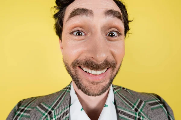 Weitwinkelbild eines fröhlichen Mannes in karierter Jacke, der isoliert auf gelb in die Kamera blickt — Stockfoto