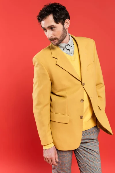 Charming guy posing in yellow jacket and looking away isolated on coral — Stock Photo